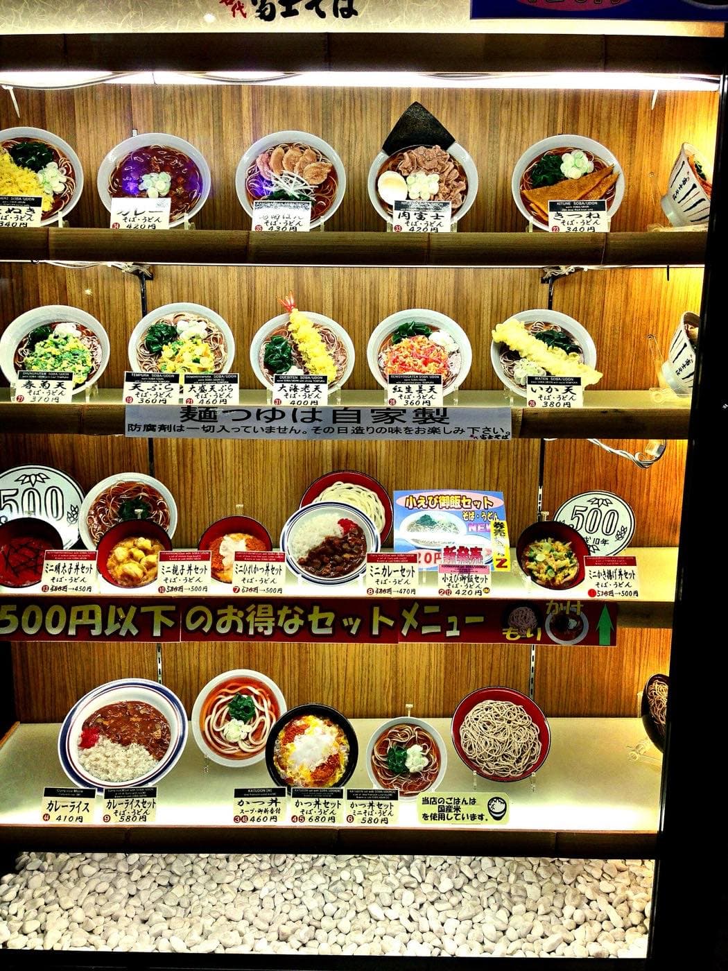 Lit display case with plastic replicas of soba, udon and rice dishes