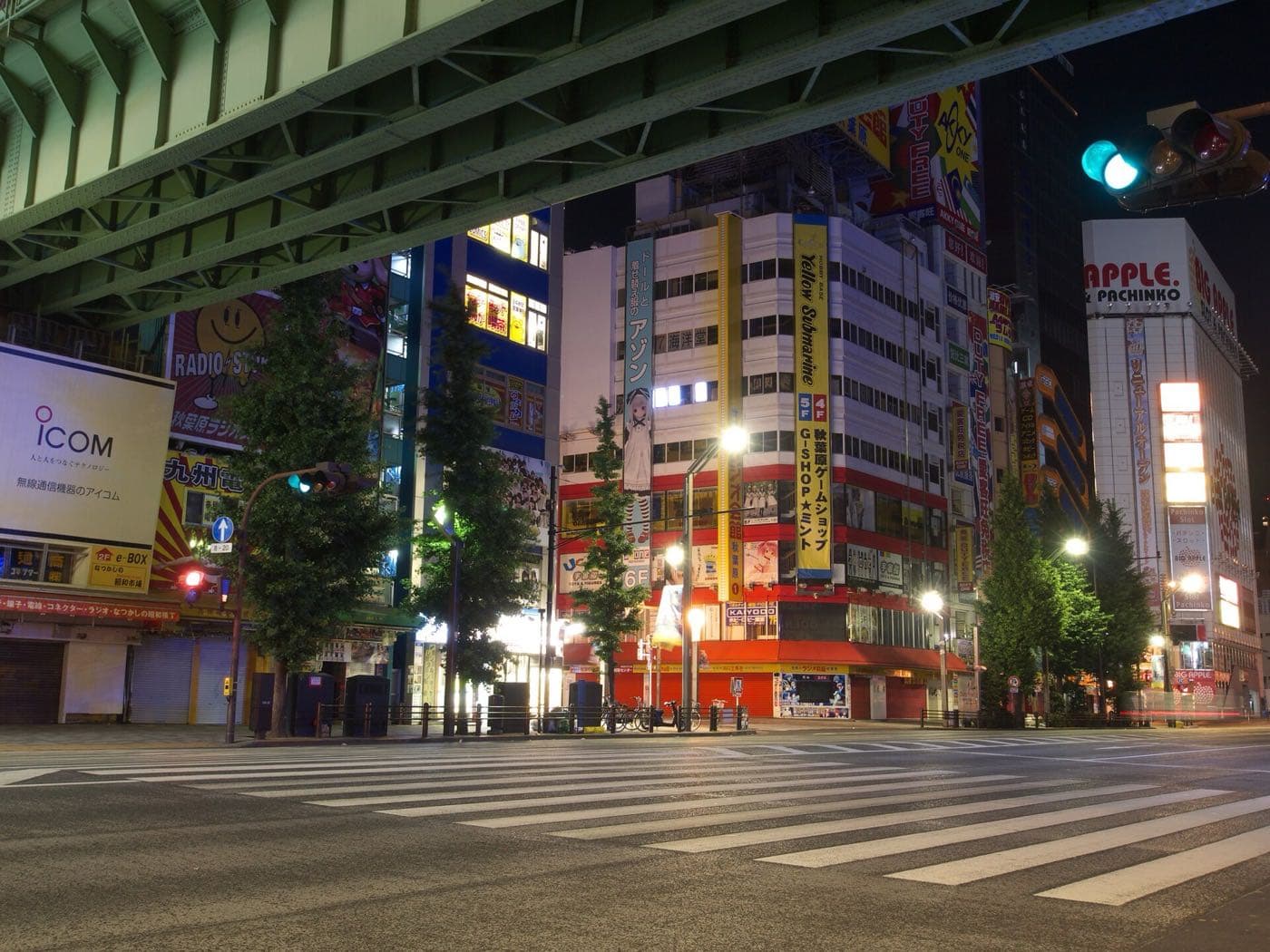 Quiet crossing on Chūō-dōri in Akihabara framed by the underside of a steel overpass