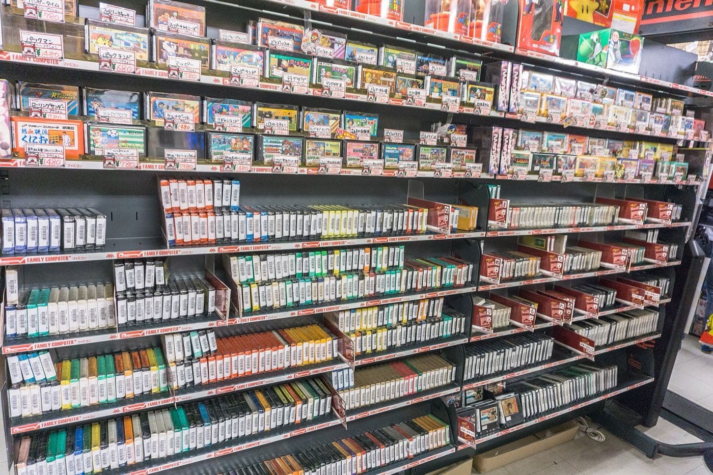 Shelves packed with boxed and loose cartridges for retro consoles